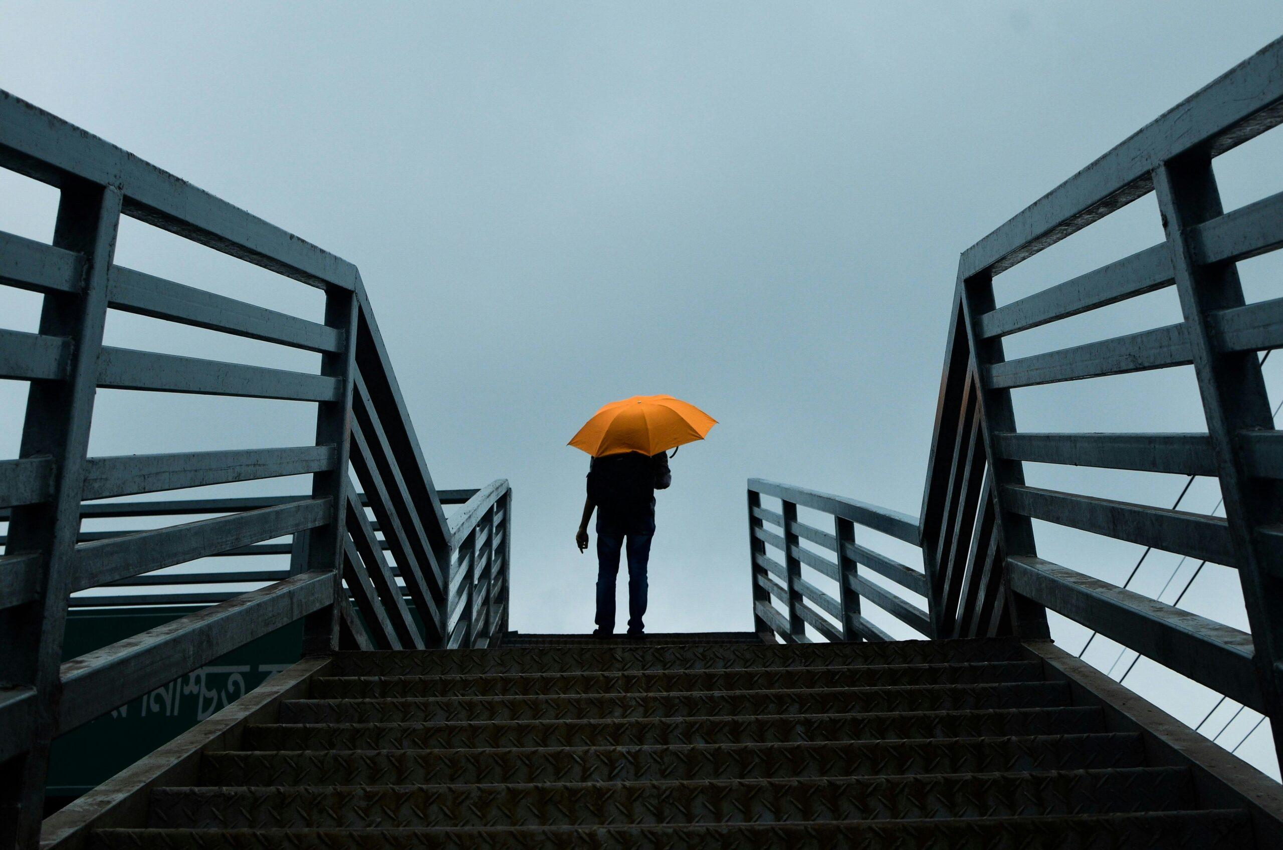 Person holding a bright umbrella in the rain